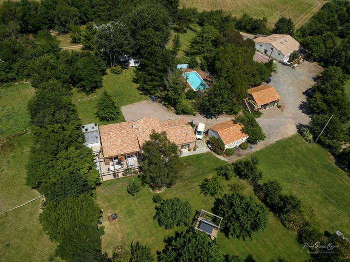 Vue du ciel du Domaine Les Rousselières avec ses bâtiments en pierre de Vendée, sa piscine et son parc verdoyant