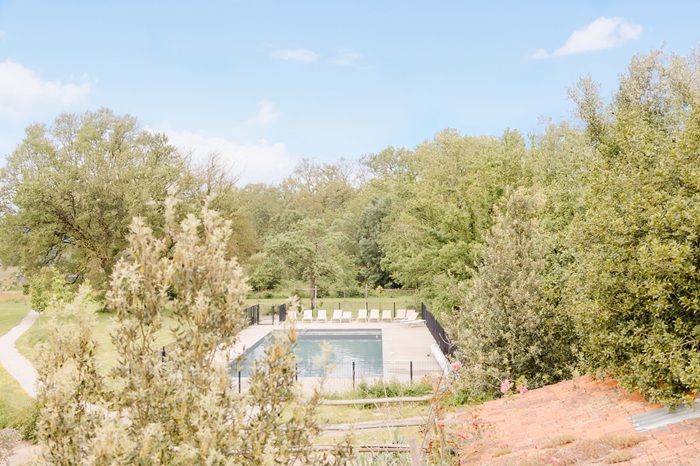 Vue aérienne de la piscine chauffée du Domaine de l’Oiselière entourée d'une végétation boisée préservée en Vendée.