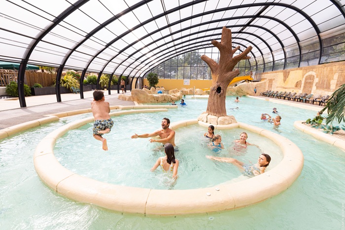 famille qui joue dans une piscine couverte