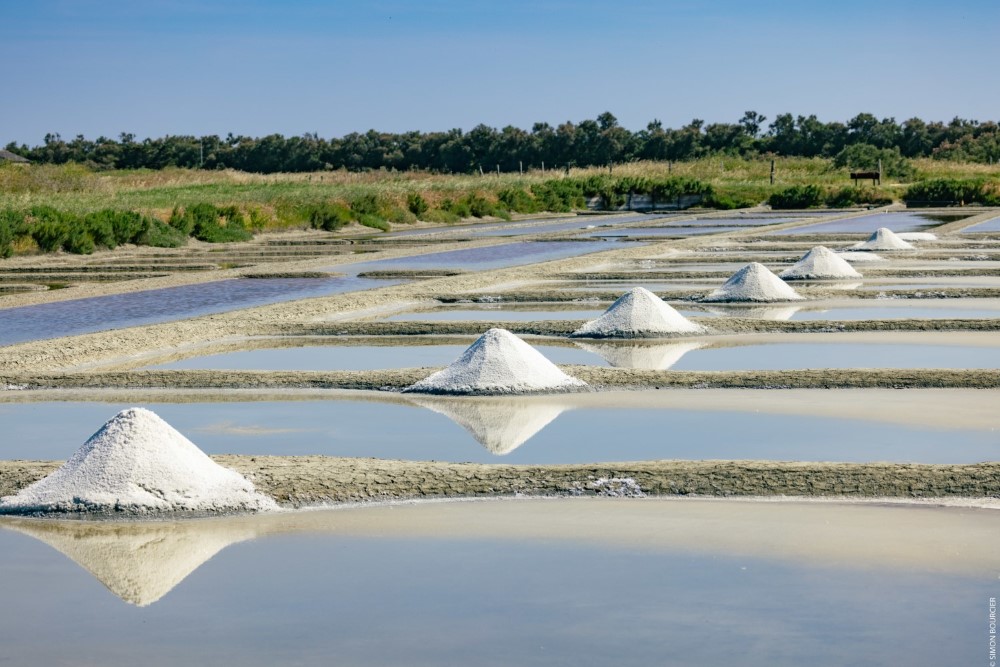 Pyramides de sel blanc se reflétant dans l'eau d'un marais salant à l'Épine sur l'île de Noirmoutier.