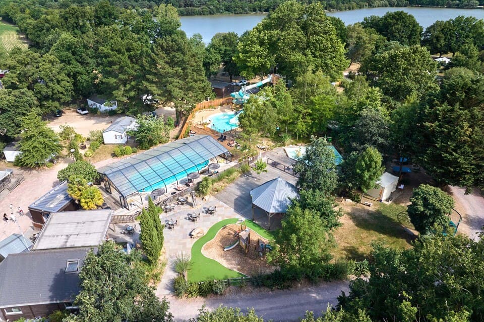 Vue aérienne du Flower Camping du Lac de La Chausselière entre forêt et lac en Vendée