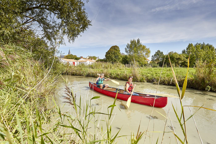Deux personnes sur une barque traversant le marais